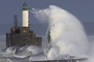 Waves crash against a lighthouse as the wind blows at around 100 kph (62 mph) Waves crash against a lighthouse as the wind blows at around 100 kph (62 mph)