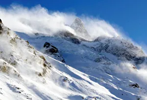 Wind blows snow off the top of a mountain in Saint-Pancrace as winter weather bringing Wind blows snow off the top of a mountain in Saint-Pancrace as winter weather bringing