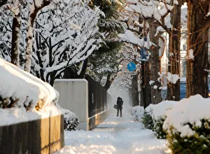 A woman and her baby make their way on a snow-covered sidewalk in Tokyo A woman and her baby make their way on a snow-covered sidewalk in Tokyo