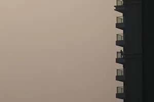 A woman cleans glass panel on a residential building during a hazy day in Shanghai A woman cleans glass panel on a residential building during a hazy day in Shanghai
