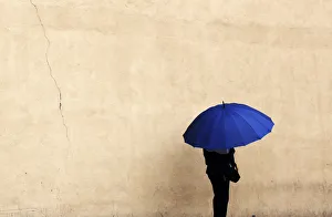 A woman holds an umbrella during a rainy day in Queens borough of New York A woman holds an umbrella during a rainy day in Queens borough of New York