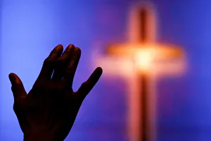 A woman raises her hand during a prayer service one day after the killing of five A woman raises her hand during a prayer service one day after the killing of five