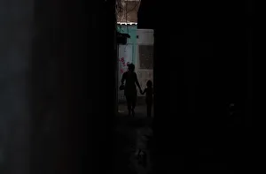 Woman walks with her daughter down an alley at Caju slum Woman walks with her daughter down an alley at Caju slum