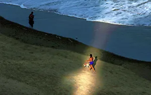 A woman walks with her dog on the Boa Viagem beach in Recife A woman walks with her dog on the Boa Viagem beach in Recife