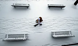 A woman walks past snow covered benches in a park in Lausanne A woman walks past snow covered benches in a park in Lausanne
