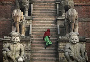 A women climbs the stairs to a temple in Bhaktapur A women climbs the stairs to a temple in Bhaktapur