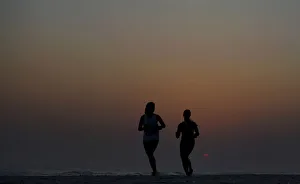 Women run during sunset on Barra da Tijuca beach in Rio de Janeiro Women run during sunset on Barra da Tijuca beach in Rio de Janeiro