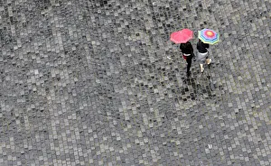 Women walk under umbrellas during a rainy day in Prague Women walk under umbrellas during a rainy day in Prague