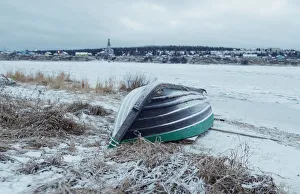 A wooden boat is seen on a bank of frozen Varzuga river in the village of Varzuga in A wooden boat is seen on a bank of frozen Varzuga river in the village of Varzuga in