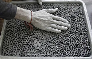 A worker fills gunpowder mixture in small paper rolls to make firecrackers at a factory A worker fills gunpowder mixture in small paper rolls to make firecrackers at a factory