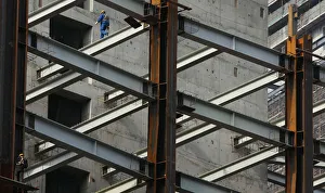 A worker walks on a steel girder at a building under construction in Nanjing A worker walks on a steel girder at a building under construction in Nanjing