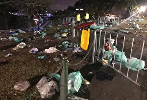 Workers look at rubbish that was left behind by spectators at a public viewing area for Workers look at rubbish that was left behind by spectators at a public viewing area for