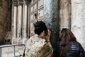 Worshippers pray next to the closed doors of the Church of the Holy Sepulchre in Worshippers pray next to the closed doors of the Church of the Holy Sepulchre in