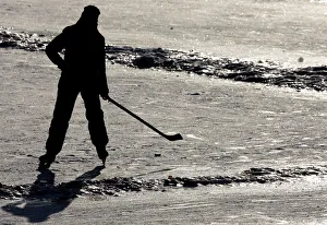 A young boy enjoys playing ice hockey on the frozen Vltava river in Prague A young boy enjoys playing ice hockey on the frozen Vltava river in Prague