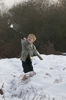 Young boy throws a snowball Kelling Norfolk December Young boy throws a snowball Kelling Norfolk December