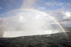 Canadian Nature Scene Prints: Rainbow forming in spray over waterfall