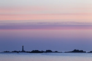 Guernsey Coastline Prints: View of coastline with lighthouse at sunset, L Eree Bay, Guernsey, Channel Islands, May