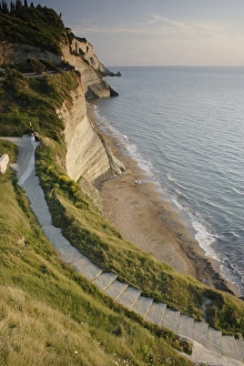 Corfu Beach Prints: View of steps down to beach from steep cliffs in evening sunlight