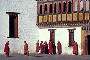Bhutan, Thimphu. The monks crimson robes stand in brilliant contrast to the Bhutan, Thimphu. The monks crimson robes stand in brilliant contrast to the