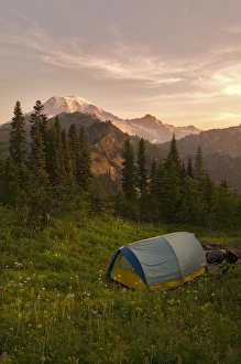 Blue backpacking tent in the Tatoosh Wilderness with a view of snow covered Mt. Rainier Blue backpacking tent in the Tatoosh Wilderness with a view of snow covered Mt. Rainier
