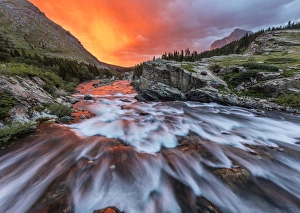 Brlliant sunrise sky over Swiftcurrent Falls in Glacier National Park, Montana, USA Brlliant sunrise sky over Swiftcurrent Falls in Glacier National Park, Montana, USA