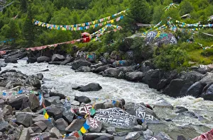 Buddhist words painted on rocks and praying flags by the river, Tagong, western Sichuan Buddhist words painted on rocks and praying flags by the river, Tagong, western Sichuan