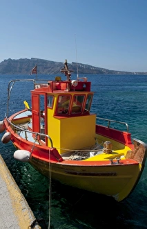 Colorful yellow fishing boat in fishing village at bottom of Oia in Santorini in Colorful yellow fishing boat in fishing village at bottom of Oia in Santorini in