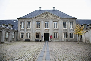 Copenhagen, Denmark - The facade of an old building with a brick courtyard in front Copenhagen, Denmark - The facade of an old building with a brick courtyard in front