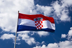 Croatian flag against blue sky and clouds, Ston, Croatia Croatian flag against blue sky and clouds, Ston, Croatia