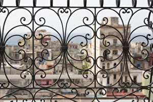 Cuba, Havana. Late afternoon rainbow and city viewed through wrought iron railing Cuba, Havana. Late afternoon rainbow and city viewed through wrought iron railing