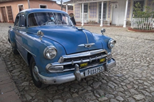 Cuba, Trinidad. Blue taxi parked on cobblestones Cuba, Trinidad. Blue taxi parked on cobblestones