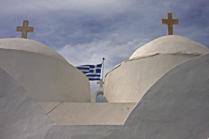 Europe, Greece, Cyclades, Sifnos, Vathi. Traditional Greek Orthodox church flying Greek Europe, Greece, Cyclades, Sifnos, Vathi. Traditional Greek Orthodox church flying Greek