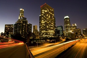 First light from sunrise illuminates downtown Los Angeles wih traffic streaking across First light from sunrise illuminates downtown Los Angeles wih traffic streaking across