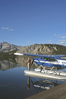 A fisherman casts for lake trout from a floatplane in scenic Takahula Lake located A fisherman casts for lake trout from a floatplane in scenic Takahula Lake located