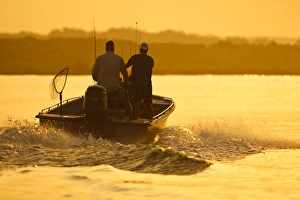 Fishermen boating toward the Laguna Madre, Texas, sunrise Fishermen boating toward the Laguna Madre, Texas, sunrise