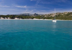France, Corsica. Sailboat anchored in clear water off white sand of Saleccio Beach France, Corsica. Sailboat anchored in clear water off white sand of Saleccio Beach