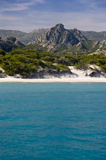 France, Corsica. White sand and clear water at Saleccio Beach below rugged terrain of DA France, Corsica. White sand and clear water at Saleccio Beach below rugged terrain of DA
