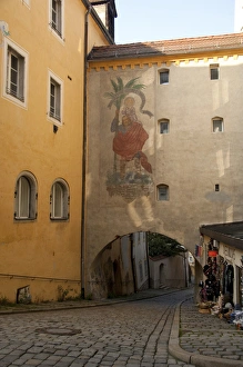 Germany, Passau. Typical narrow cobblestone street of Passau, historic wall painting Germany, Passau. Typical narrow cobblestone street of Passau, historic wall painting