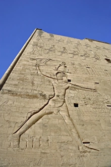 Giant figures and hieroglyphs on pylons of main entrance to Temple of Horus, at Edfu Giant figures and hieroglyphs on pylons of main entrance to Temple of Horus, at Edfu