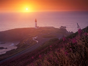 A golden glow sets over Yaquina Head Lighthouse as the sun sets over the ocean, Oregon A golden glow sets over Yaquina Head Lighthouse as the sun sets over the ocean, Oregon