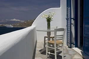 Images Dated 2nd June 2005: Greece, Mykonos, Hora. Balcony table and chairs with a docked cruise ship in the distance