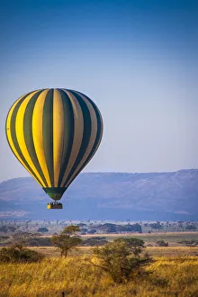 A hot-air balloon slowly traverses over the Serengeti plain A hot-air balloon slowly traverses over the Serengeti plain