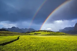 Italy, Dolomites, Alpi di Siusi. Double rainbow over mountain meadow Italy, Dolomites, Alpi di Siusi. Double rainbow over mountain meadow