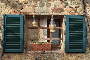 Italy, Monteriggioni. Stone wall, curtained window with blue shutters Italy, Monteriggioni. Stone wall, curtained window with blue shutters