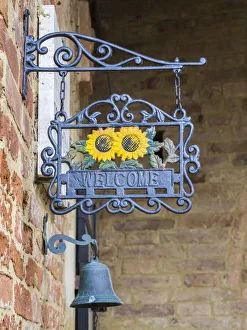 Italy, Tuscany. A wrought iron welcome sign in the village of Chiusure in the province of Italy, Tuscany. A wrought iron welcome sign in the village of Chiusure in the province of