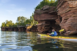 Kayaker exploring the sea caves of Devils Island in the Apostle Islands National Lakeshore Kayaker exploring the sea caves of Devils Island in the Apostle Islands National Lakeshore