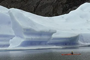 Kayakers exploring Grey Lake amid large iceberg, Torres del Paine National Park Kayakers exploring Grey Lake amid large iceberg, Torres del Paine National Park