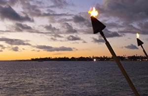 Kona Hawaii Big Island tiki fire light over Ocean at Kailua-Kona beach at sunset Kona Hawaii Big Island tiki fire light over Ocean at Kailua-Kona beach at sunset