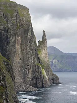The landmark Trollkonufingur in the cliffs of the island of Vagar, part of the Faroe Islands The landmark Trollkonufingur in the cliffs of the island of Vagar, part of the Faroe Islands
