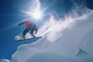 Man jumping off a large cornince on a snowboard on Flagstaff Peak in the Wasatch Man jumping off a large cornince on a snowboard on Flagstaff Peak in the Wasatch